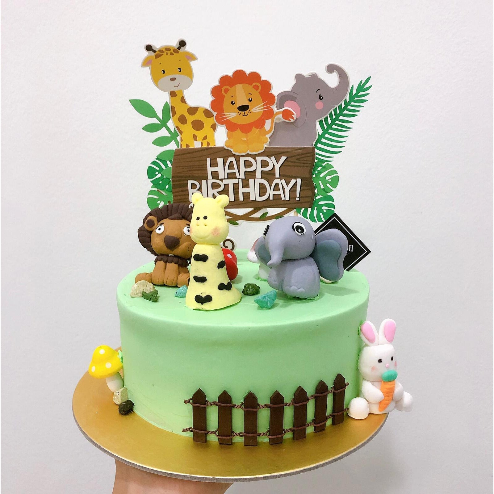 Special made first birthday cake for a boy featuring zoo animals in between  two tiers of